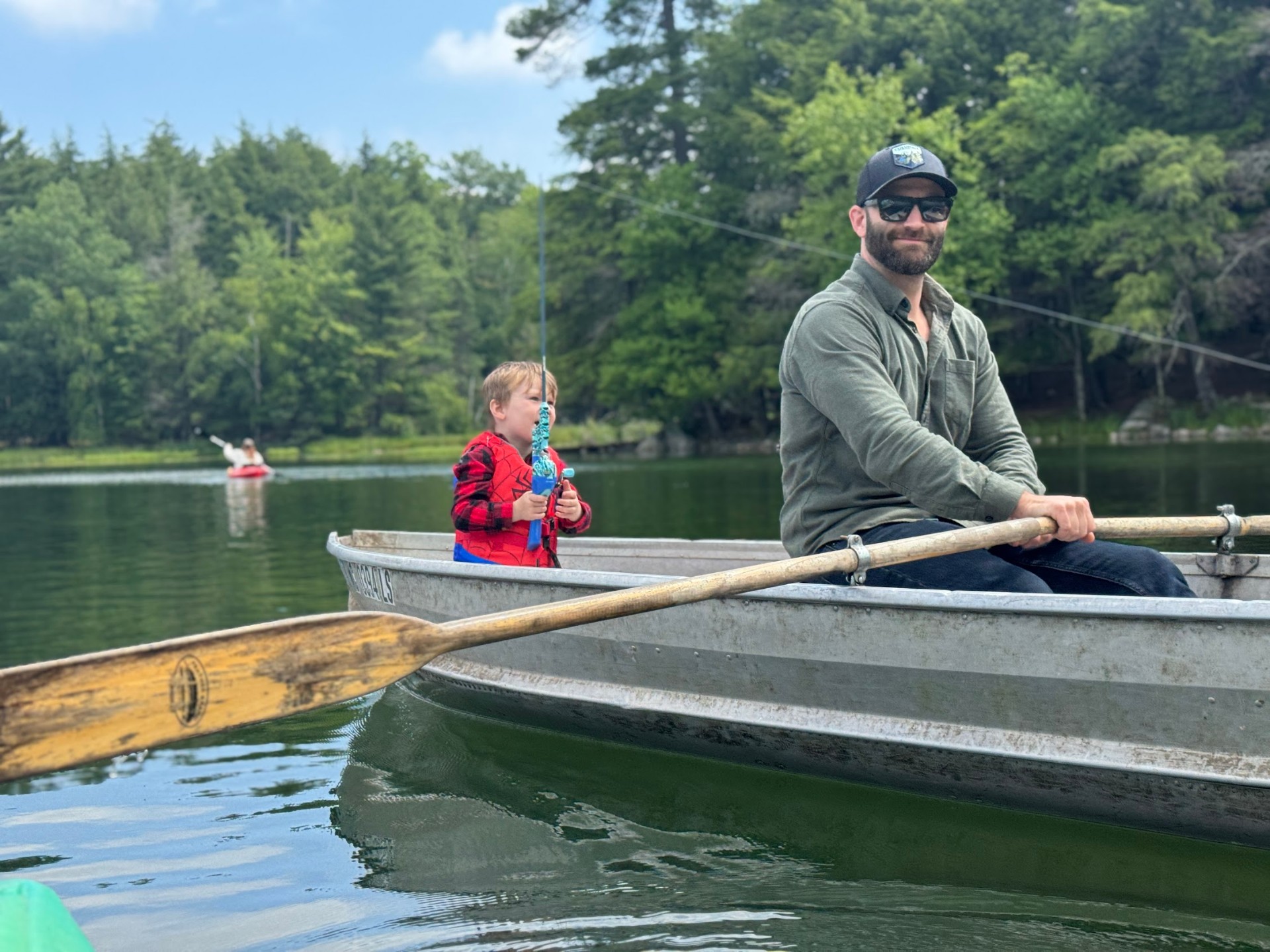 Jordan rowing a boat on the lake with his son fishing